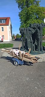 Skulptur und Holzkarren im Freien