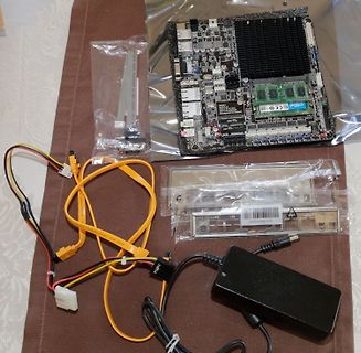 Mainboard, Netzteil und Kabel auf Tisch