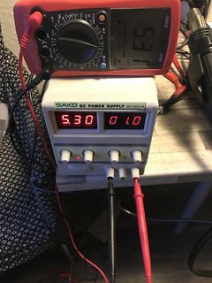 Multimeter und Labornetzteil auf Werkstattunterlage