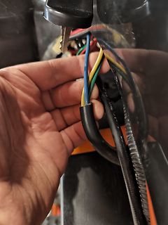 Hand hält bunte Kabel in einem Gerät