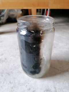 Glasgefäß mit dunkler Substanz
