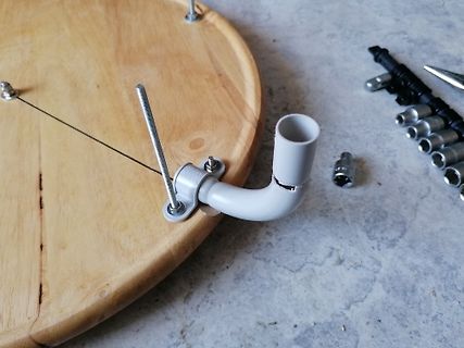 Mechanischer Aufbau mit Holzbrett und Rohrbogen