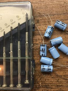 Schraubendreher-Set und Elektrolytkondensatoren auf Holzuntergrund