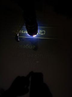 Taschenlampe beleuchtet Text auf weißem Untergrund