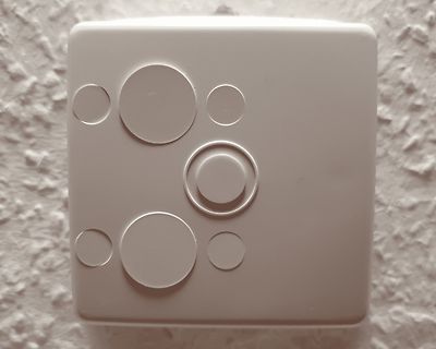 Weißer Kunststoffdeckel mit kreisförmigen Aussparungen