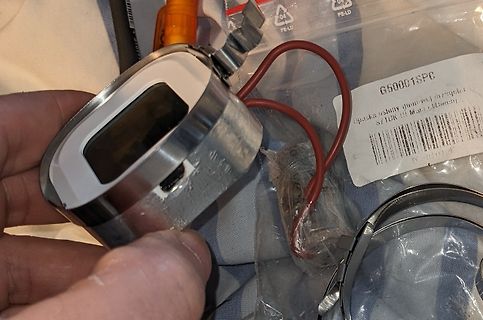 Hand hält elektronisches Bauteil mit Display und Kabeln