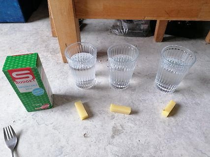 Gläser mit Wasser, Salzpackung und Käsewürfel