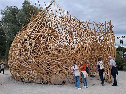Große Holzskulptur im Freien mit Personen