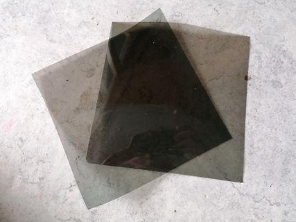 Zwei dunkle, transparente Platten auf hellem Untergrund