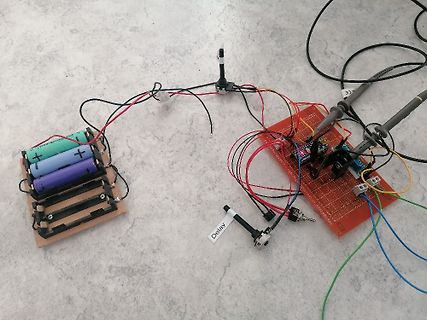 Elektronik-Versuchsaufbau mit Batterien und Lochrasterplatine