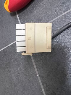 Stecker eines Flachbandkabels auf Fliesenboden