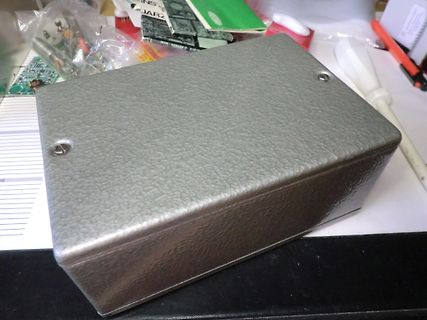 Graues Metallgehäuse auf Werkstattunterlage