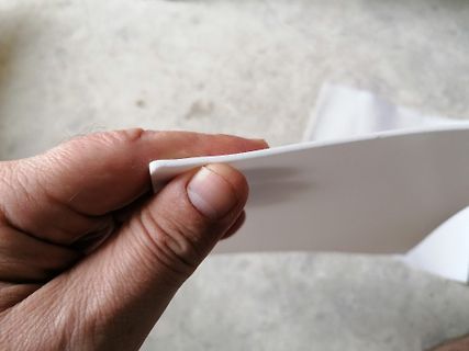 Hand hält ein weißes Blatt Papier