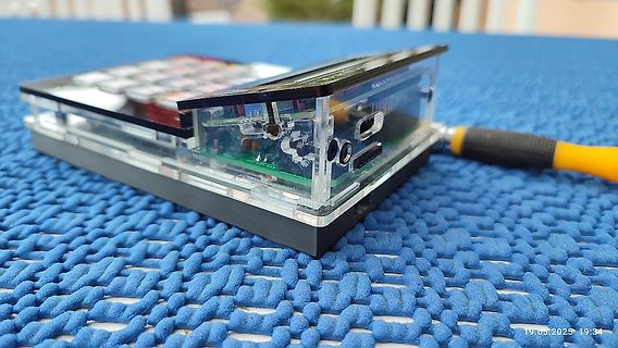 Elektronikgerät in transparentem Gehäuse auf blauem Untergrund