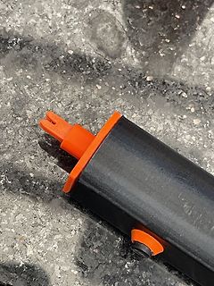 Nahaufnahme eines schwarzen Bauteils mit orangefarbenem Stecker