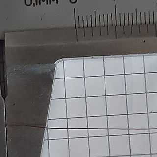 Nahaufnahme eines Messschiebers und Millimeterpapier