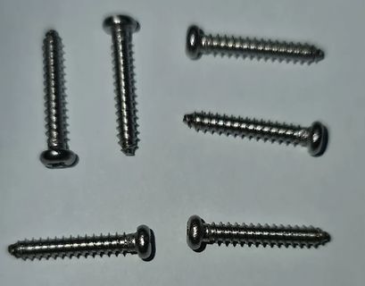 fünf Metallschrauben auf weißem Grund