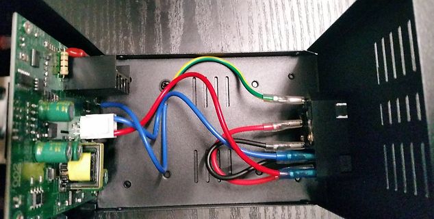 Innenansicht eines Netzteils mit Kabeln und Platine