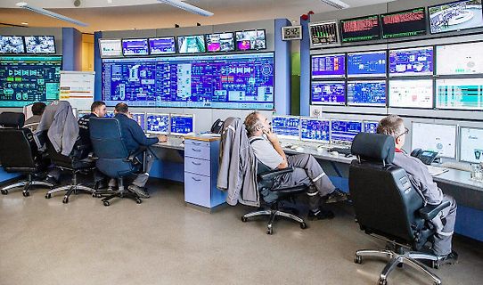 Mitarbeiter in einer Leitwarte mit Überwachungsmonitoren