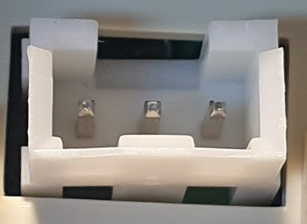 Weißer Kunststoffstecker mit drei Metallkontakten