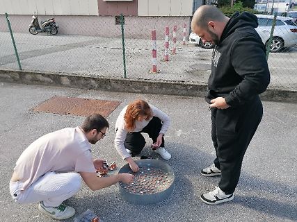 Personen im Freien mit einer Schale voller kleiner Objekte