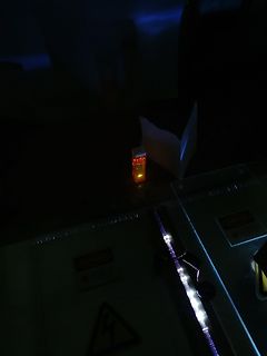 Dunkle Aufnahme eines beleuchteten Bauteils und einer Lichtquelle