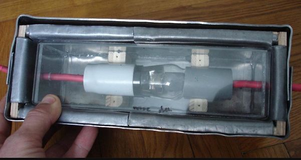 Experimenteller Aufbau mit Glasröhre und Metallgehäuse