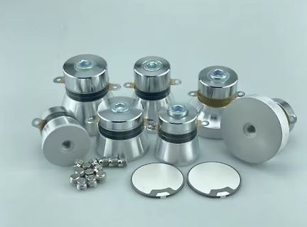 Metallische Bauteile und kleine Zylinder auf hellem Grund