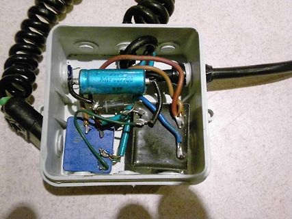 Geöffnetes Gehäuse mit Elektrolytkondensator und Bauteilen