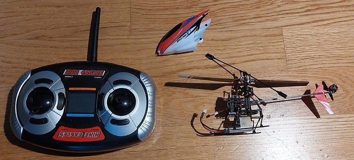 Fernsteuerung und RC-Hubschrauber auf Holzboden