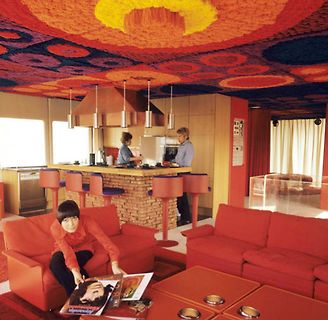 Retro-Wohnzimmer mit orangefarbenem Teppich und Möbeln
