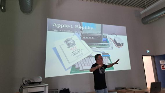 Mann präsentiert Apple-1 Replika auf Leinwand