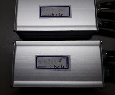 Zwei silberne Metallgehäuse mit Aufklebern