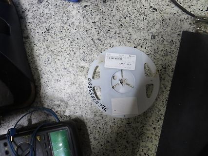 Spule auf Kunststoffspule, Multimeter auf Werkstattuntergrund