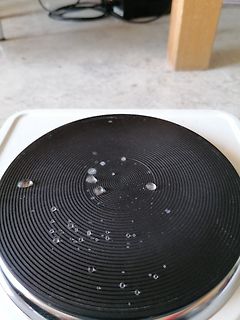 Schwarze Kochplatte mit Wassertropfen
