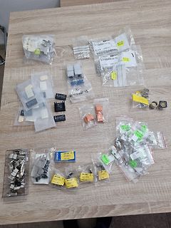 Verschiedene elektronische Bauteile in Plastikbeuteln auf Holztisch