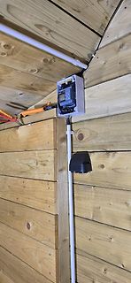 Elektronikkomponente in Gehäuse an Holzwand