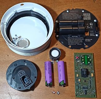 Zerlegter Rauchmelder mit Platine und Batterien