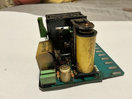 Beschädigte Leiterplatte mit verbranntem Transformator und Kondensator