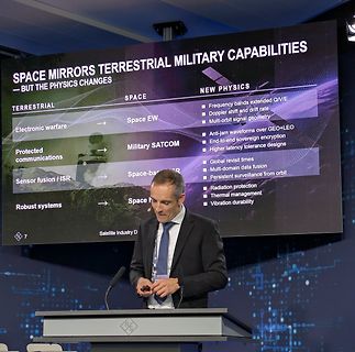 Mann vor Präsentationsbildschirm über Weltraum-Militärkapazitäten