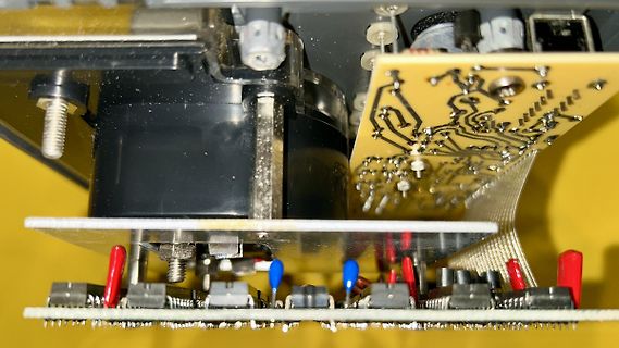 Nahaufnahme einer Leiterplatte mit Flachbandkabel und Bauteilen