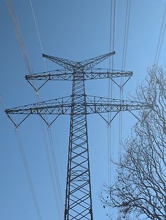 Hochspannungsmast vor blauem Himmel