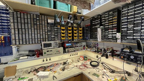 Elektronik-Werkstatt mit Messgeräten und Bauteilboxen