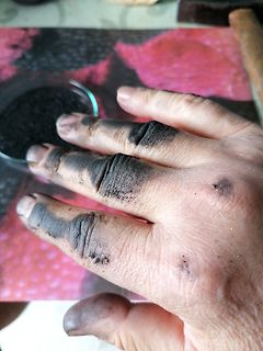 Schmutzige Hand mit schwarzem Pulver