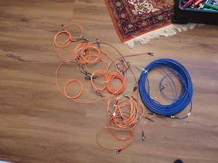 Orangefarbene und blaue Kabel auf Holzboden