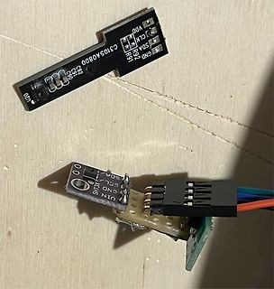 Zwei kleine Leiterplatten mit I2C-Anschlüssen auf Holzuntergrund