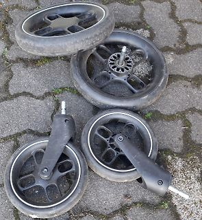 Vier Räder eines Rollators auf Pflastersteinen