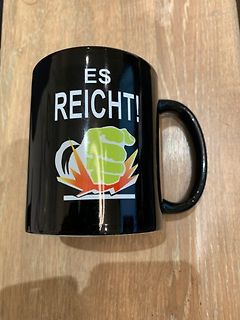 Schwarze Tasse mit Aufdruck und Faust-Grafik