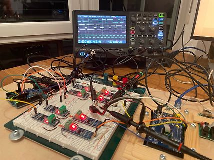 Elektronik-Versuchsaufbau mit Breadboard, Oszilloskop und Mikrocontroller