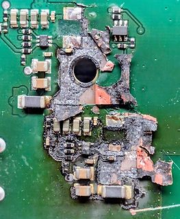 Beschädigte Leiterplatte mit massiven Verbrennungen und Bauteilverlust